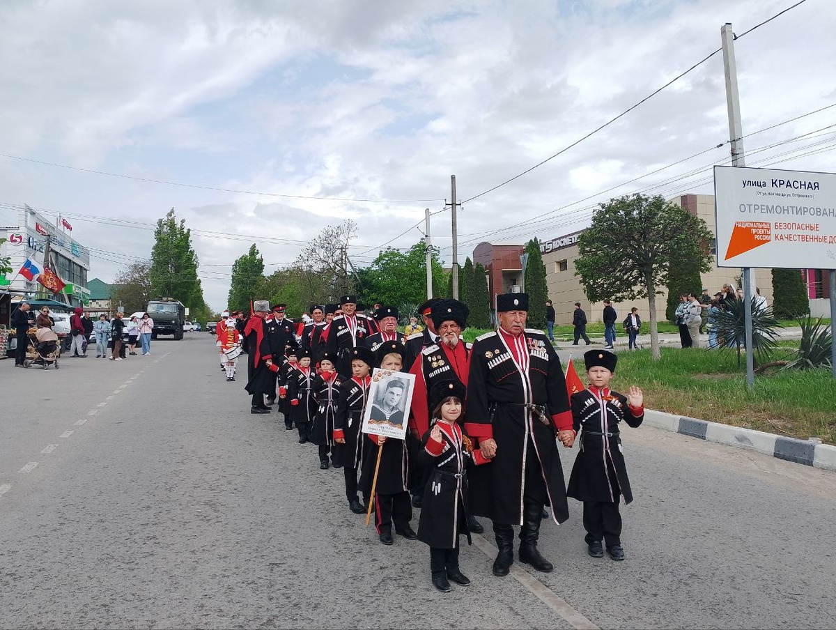 Строй казаков. Посередине деды, они держат за руку маленьких казачат. Все в форме