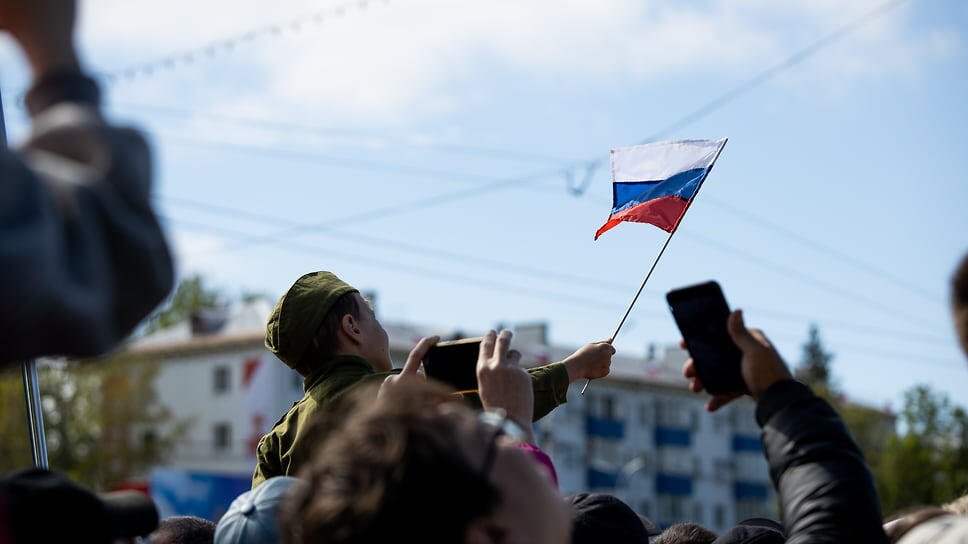 Ребенок с флагом Российской Федерации на фоне толпы.📷Фото: Ксения Федорова, Коммерсантъ / Коммерсантъ
