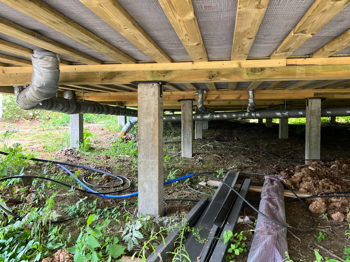 Вид на подполье каркасного дома, выполненного на фундаменте из железобетонных свай