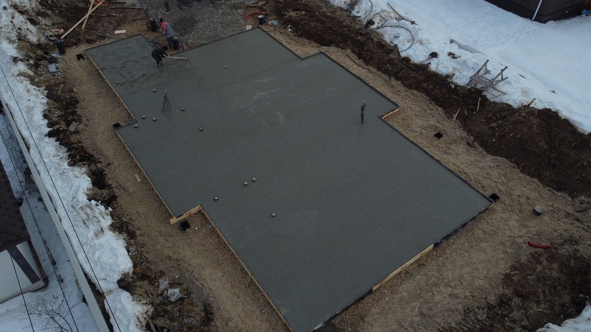 Залитый монолитный плитный фундамент с выпусками инженерных сетей (канализации, водоснабжения и электроснабжения)