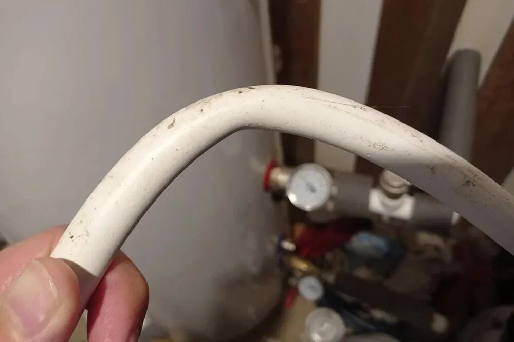 Это залом металлопластиковой трубы: трубу слишком сильно согнули. В месте залома труба сузилась, вода пойдет хуже