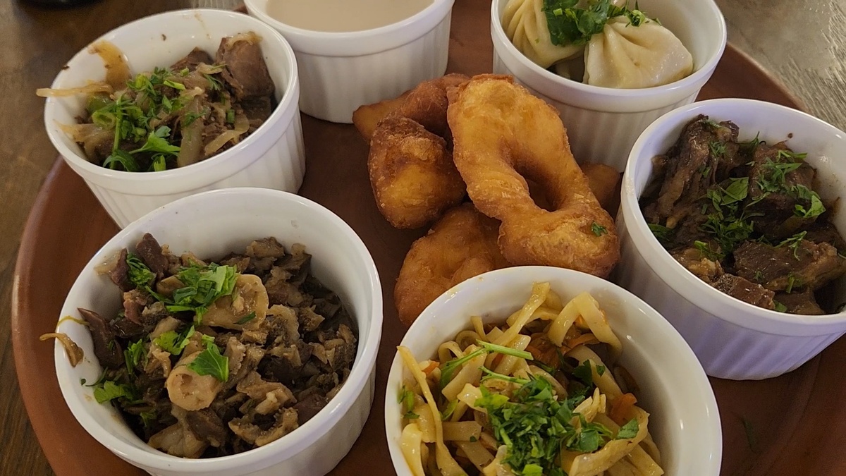 Дегустационный сет. По часовой стрелке: джомба – калмыцкий чай с молоком, берики  – местные пельмешки, жареная верблюжатина, хурсн махн – говядина с лапшой, дотур – субпробукты барашка и жареное мясо яка. В центре борцоки – выпечка. Что могу сказать, продегустировав: баранина – это не мое, все остальное было очень вкусно