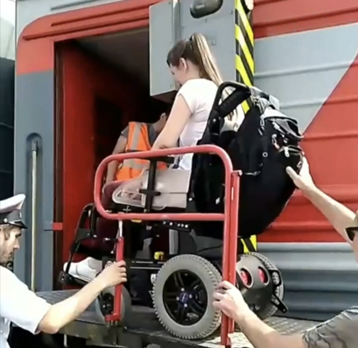 Меня на электрическом подъёмнике грузят в вагон поезда