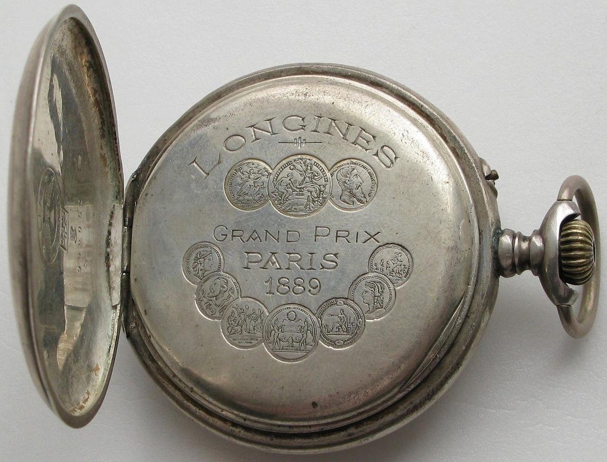 Одна из первых моделей Longines с заводной головкой вместо ключа. На задней крышке - изображения полученных наград.
