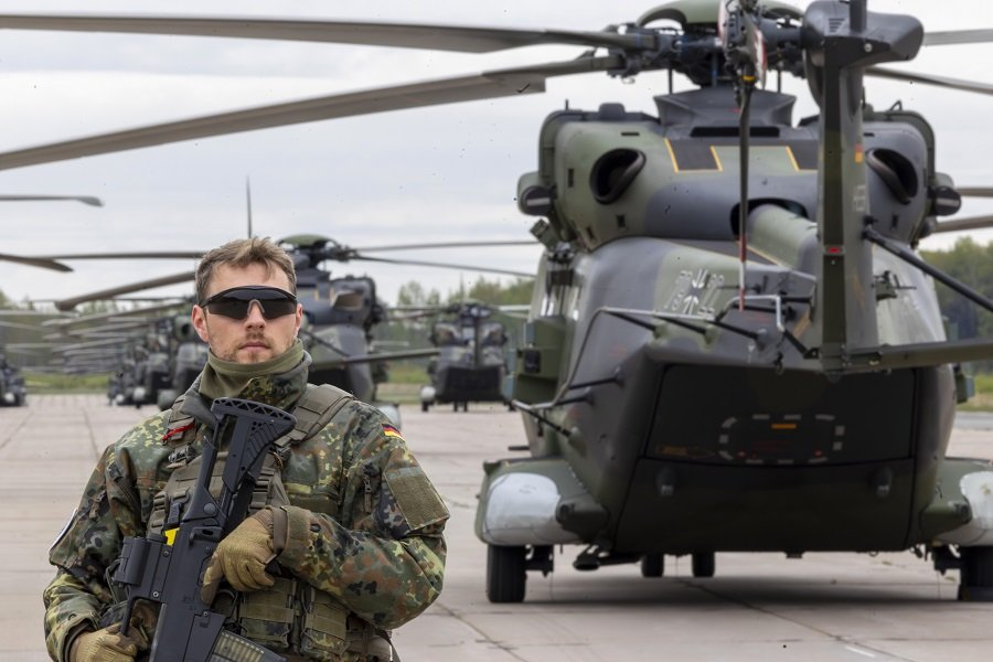 Военнослужащий перед вертолетами во время военных учений НАТО - Фото: AP/TASS