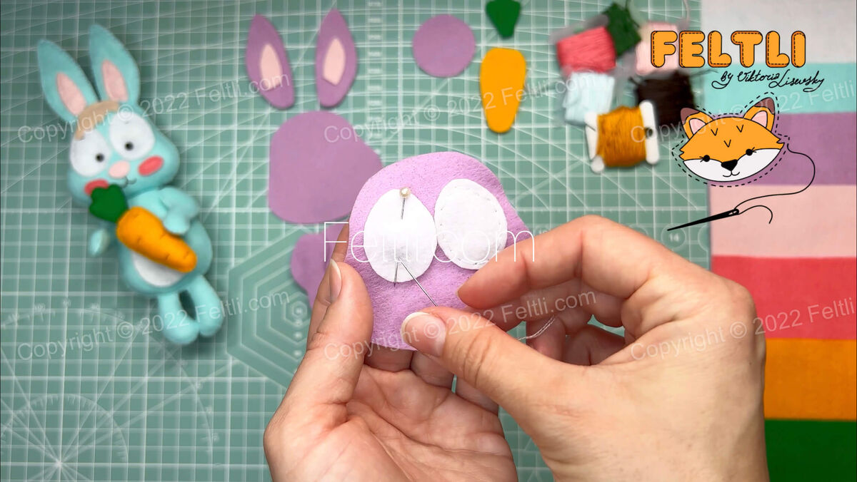 Шаг 2. Начнем формировать голову кролику. Швом «назад иголка» пришиваем к верхнему слою головы зону глазок белого цвета. Стежки не делайте широкими. Закрепите портновскими булавками для удобства. 
