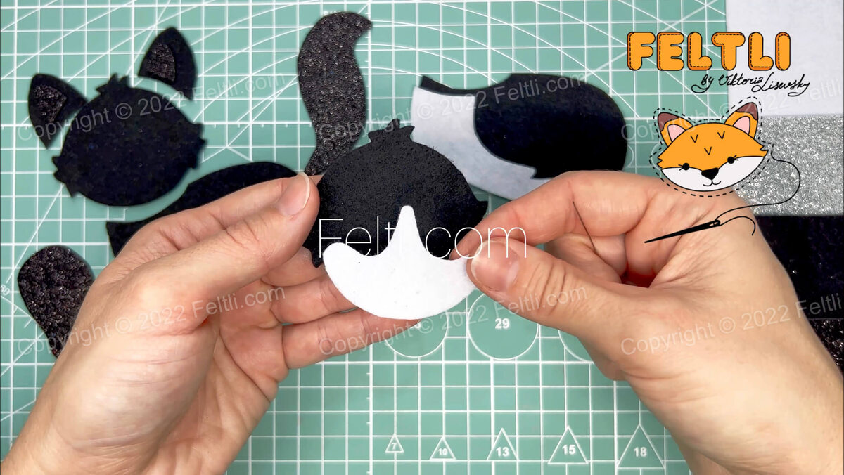 Шаг 2. Начнём с формирования мордочки котика. Если используете тёмные материалы в пошиве, советую дополнить мордочку светлым элементом выкройки (показано на фото в шаге 2), таки образом мордочка будет более выразительной. Светлый участок накладываем на верхний слой мордочки и пришиваем швом «назад иголка». 