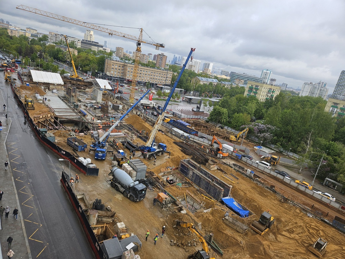 📷 1.1: В западном торце площадки началась обратная засыпка песком готового верхнего перекрытия станции. Ведётся крепление брезента на металлоконструкциях временного навеса над зоной проведения работ по строительству пересадки (для защиты от осадков на период демонтажа верхнего перекрытия станции Калужско-Рижской линии). Активно возводятся вентиляционные киоски станции.