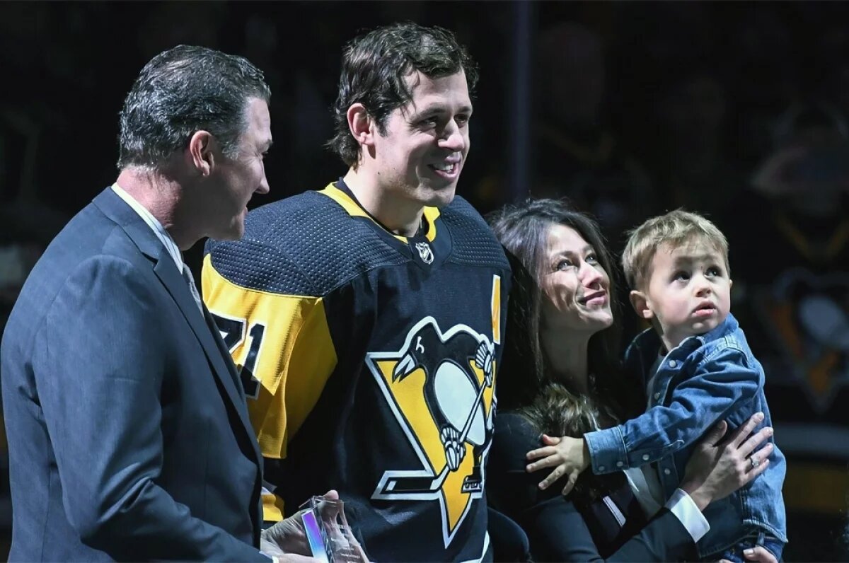    Евгений Малкин с женой Анной Кастеровой и сыном Никитой во время предматчевой церемонии чествования 1000-го очка Малкина за карьеру в НХЛ Eishockey Herren USA перед игрой НХЛ между «Питтсбург Пингвинз» и «Сент-Луис Блюз» 16 марта 2019 года.