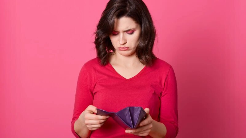     Женщина с грустью смотрит в кошелек. Фото: ru.freepik.com, автор user18526052.
