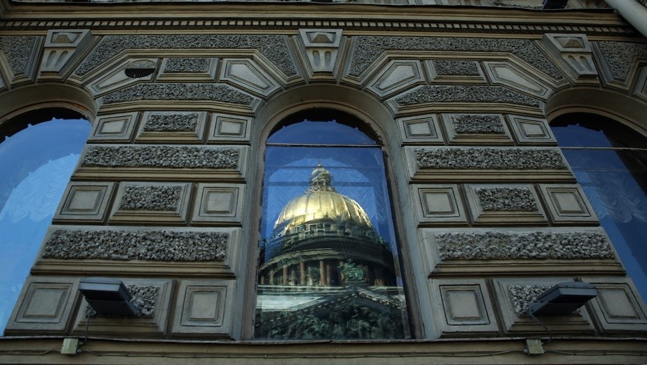    Отражение Исаакиевского собора в окне многоквартирного дома в Петербурге. Автор фото: Петр Ковалев / "Деловой Петербург"