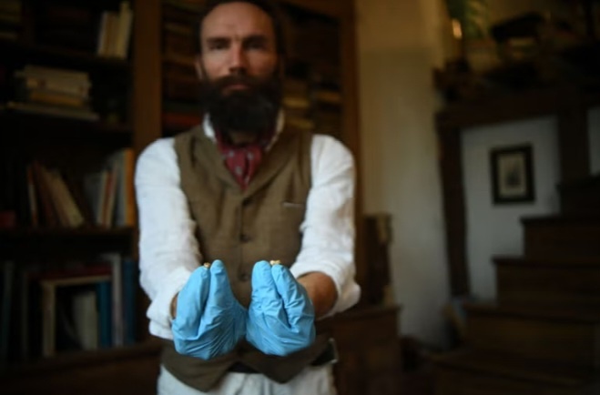 Людовик Слимак, сфотографированный в 2022 году, позирует с молочными зубами как homo sapiens, так и неандертальца.