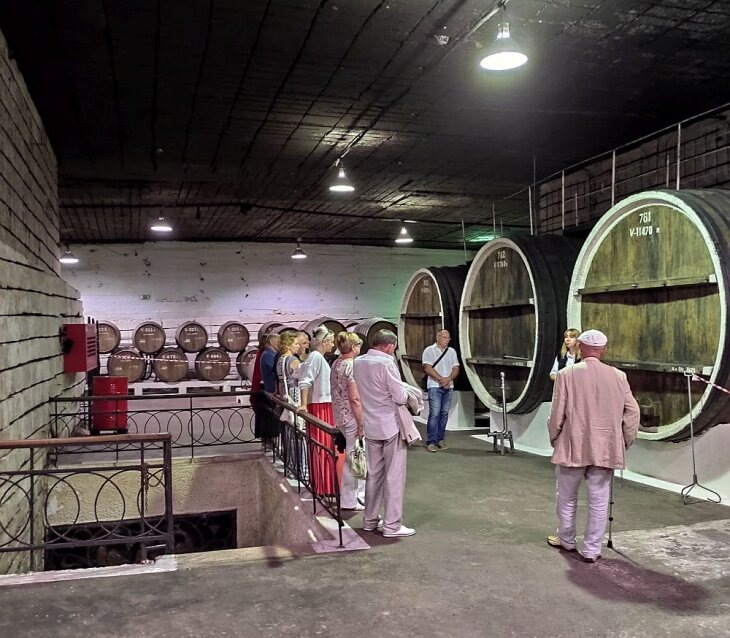     Туристы на экскурсии в подвалах Инкерманского завода марочных мин. Фото Кирилла Сомова.