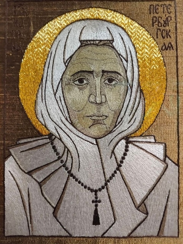 Шитая икона «Матронушка-босоножка Петербургская». Автор проекта и исполнитель: В.Б. Казарина, прорись: О.А. Мамонова. Мастерская Константино-Еленинского женского монастыря «Покров». Тафта, нить шелковая, нить металлизированная, полотно льняное;  шитье шелком в раскол, шитье золотное в прикреп, крашение ручное, 23,5х17,6 см. Из собрания Государственного музея истории религии