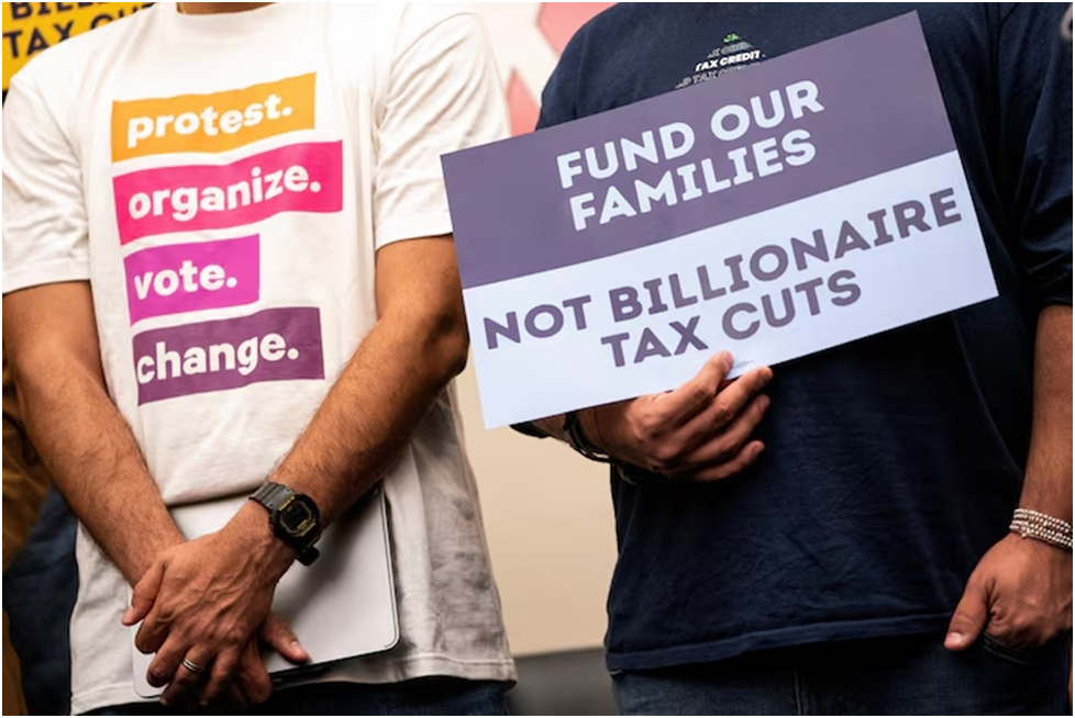 Демонстранты держат плакаты во время пресс-конференции, посвящённой сокращению расходов на программу Medicaid, Программу дополнительной продовольственной помощи (SNAP) и налоговый вычет на детей, на Капитолийском холме в Вашингтоне, округ Колумбия, США, 13 мая 2025 года. REUTERS/Nathan Howard/File Photo