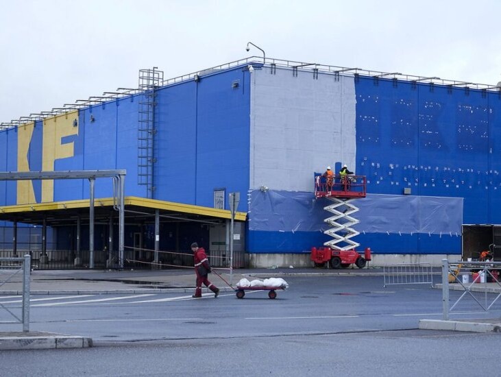    Рабочие закрашивают логотип Ikea на фасаде магазина Ikea в Санкт-Петербурге. 27 октября 2022 года. Источник: AP.