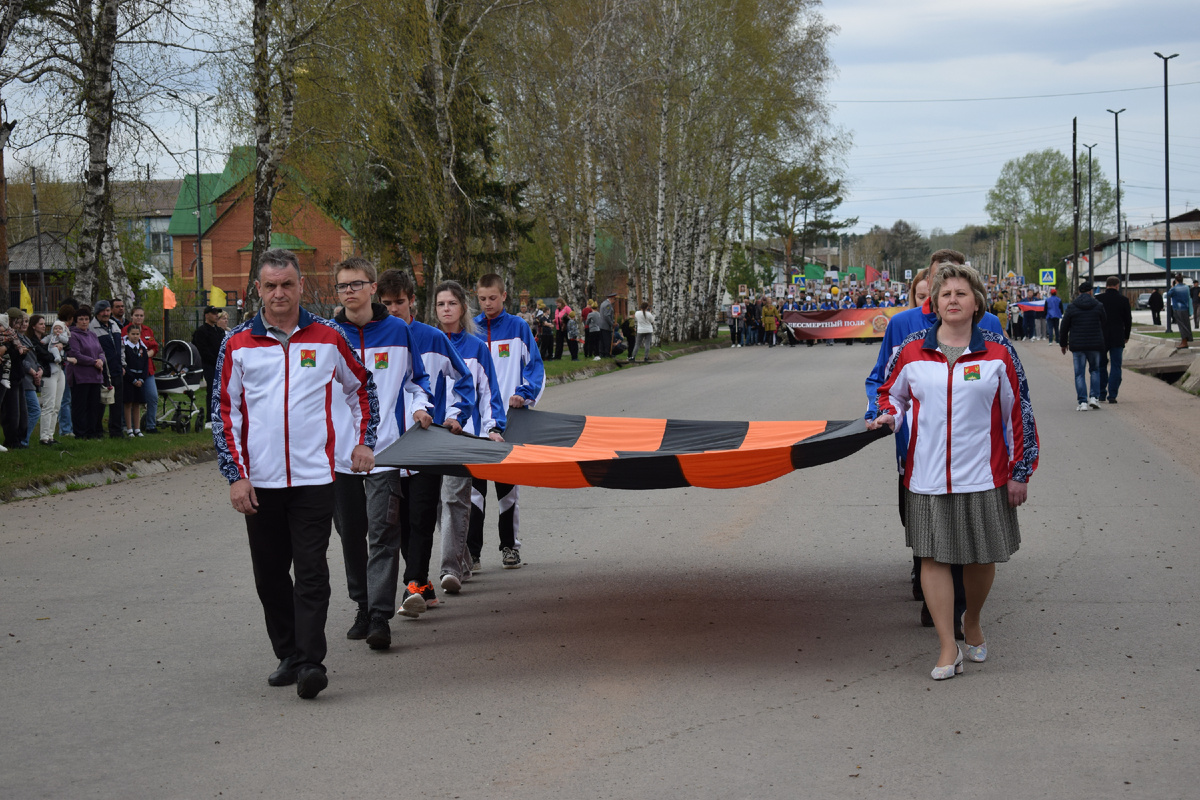 Георгиевский флаг внесли спортсмены Саянского района, преподаватели Спортивной школы и тренеры.