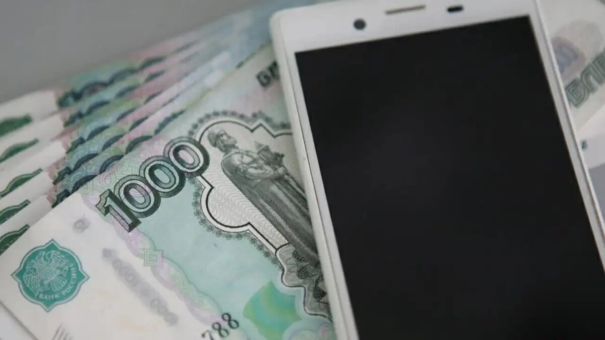    Российские рубли и мобильный телефон.
