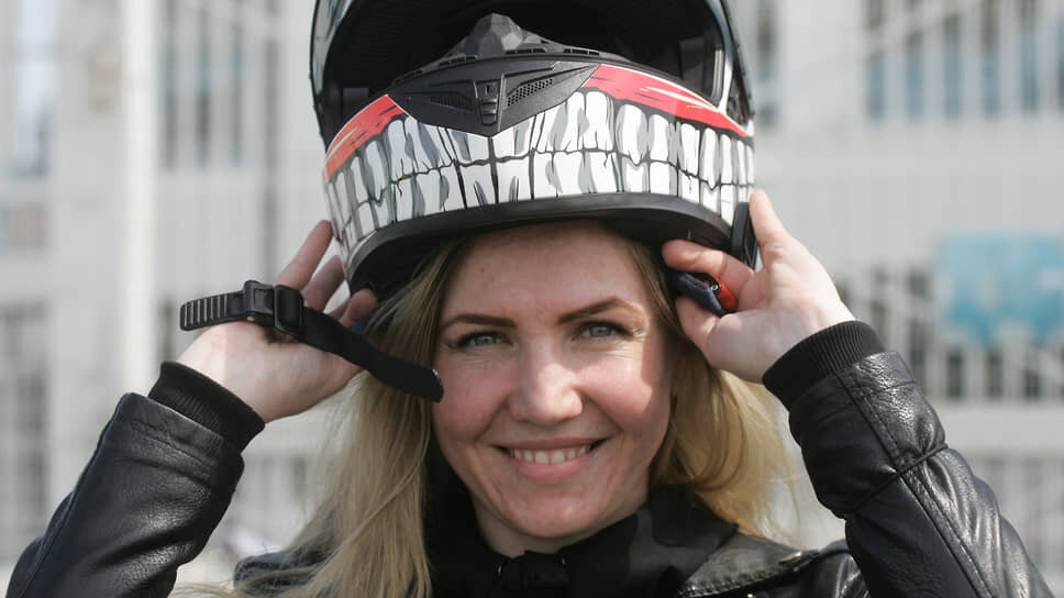 Девушка надевает мотоциклетный шлем с рисунком черепа.📷Фото: Роман Яровицын / Коммерсантъ