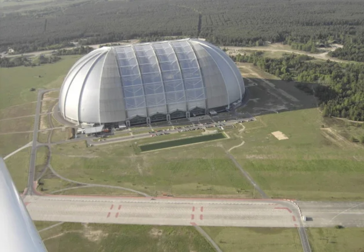 Размеры 360 × 210 × 107 м (как 6 футбольных полей).  Купол выдерживает снег и ветер до 120 км/ч.  Освещение днём - естественный свет через прозрачные панели, вечером - искусственная подсветка, имитирующая закат.  Влажность 50–60% (как в тропиках).  