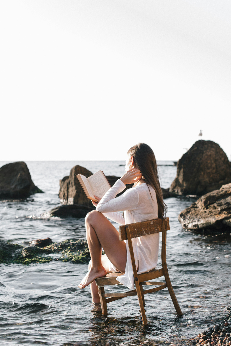 https://unsplash.com/photos/woman-in-white-dress-sitting-on-brown-wooden-chair-reading-book-on-beach-during-daytime-OnzI0zsgfEM?utm_content=creditShareLink&utm_medium=referral&utm_source=unsplash