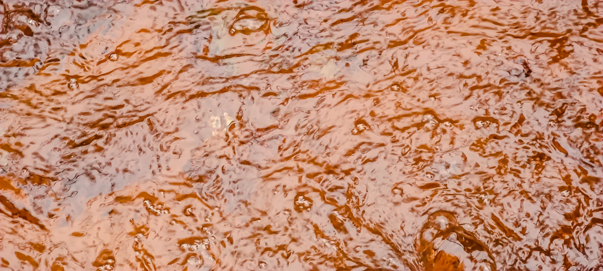 Вода прозрачная, но камни, находящиеся в колодце покрыты густым ярко-ржавым налетом))