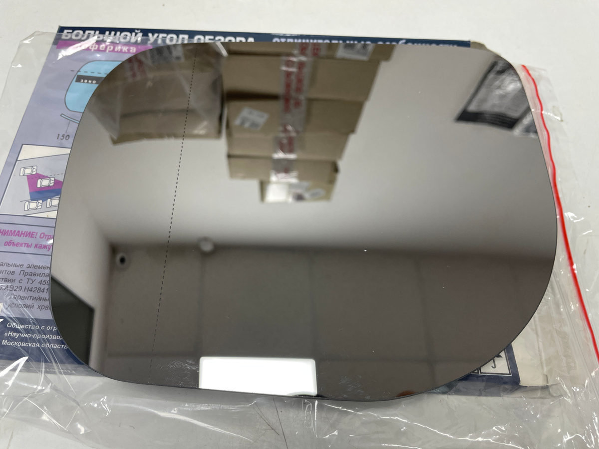 На фотографии асферический зеркальный элемент с прерывистой линией, обозначающей разделение зеркала на прямое и искривлённое.