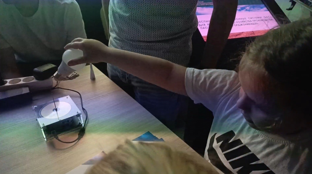 Катя зажикает лампочку от катушки Тесла.