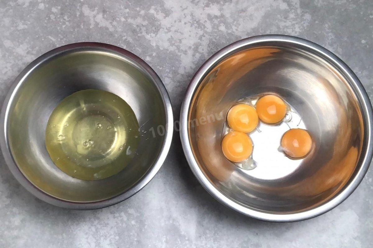 Яйца разделите на желтки и белки. Старайтесь это сделать аккуратно, чтобы в белки не попала ни капелька желтка, иначе белки не взобьются. Белки на время дальнейшего приготовления уберите в холодильник.