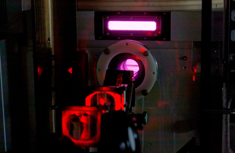 Оптические элементы и лазерный свет, показанные здесь, использовались исследовательской группой для измерения некоторых свойств импульсной плазмы внутри травильной камеры машины.