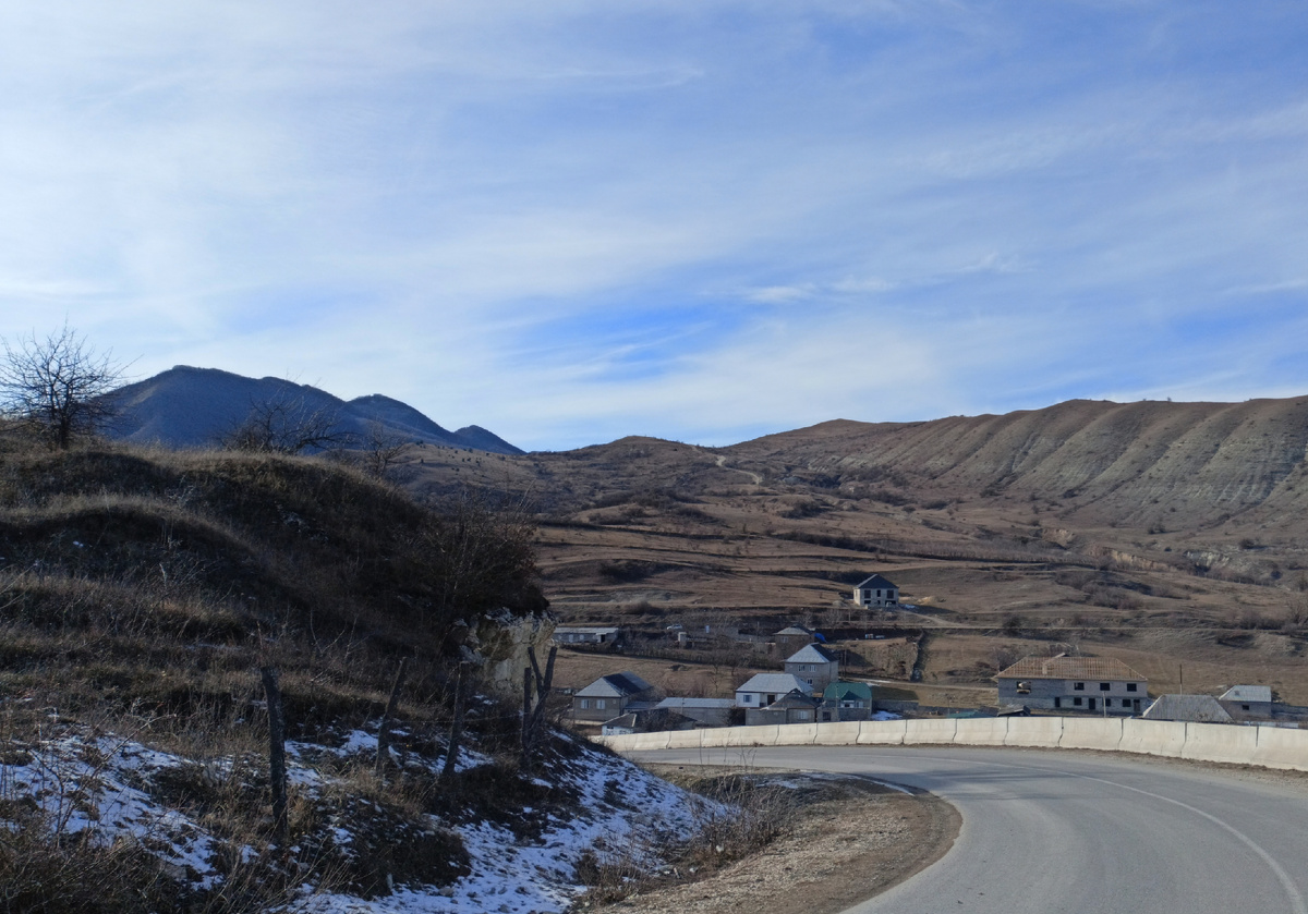 Фото автора: поворот горной дороги, край горного села и сами горы (Дагестан, январь 2024)