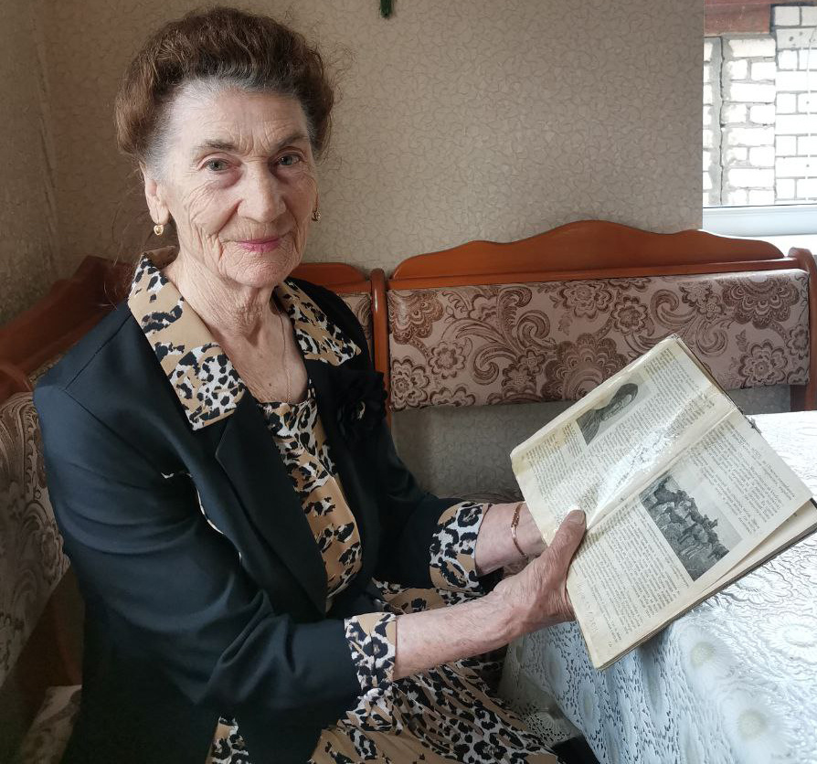 Мариям Кокаевна Муссакаева с семейной реликвией - стареньким учебником «Коневодство». Фото автора.