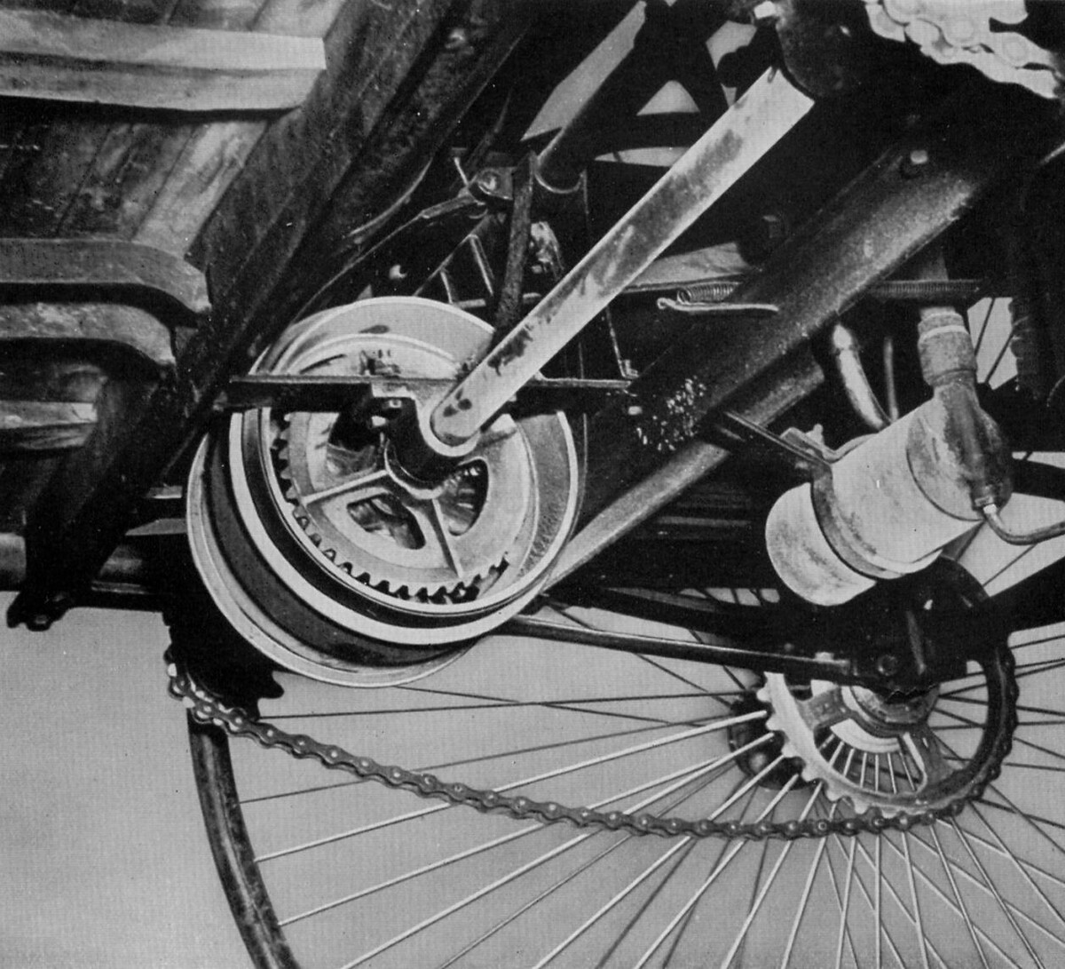 Конструкция ременной системы привода — Benz Patent-Motorwagen Карла Бенца.
Крутящий момент от двигателя передавался на задние колеса с помощью мудреной системы шкивов, шестерен и ремней. Присутствовала и главная коническая передача (без дифференциала), а рядом располагался тормозной барабан, а также полуоси и примитивная подвеска на двойных полуэллиптических рессорах. Переднее колесо подвески не имело.
Роль сцепления в машине выполнял простой двухпозиционный размыкатель, а огромное горизонтальное колесо маховика являлось по совместительству еще и ручным стартером. Генератора на Benz Patent-Motorwagen не было, как отсутствовала и коробка передач. О бензонасосе тоже речи не шло: топливо подавалось самотеком из бака, который был расположен над силовым агрегатом.