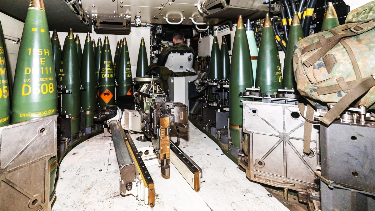 Размещение снарядов в кассетах механизированной боеукладки. В центре- захват-манипулятор механизма подачи. В дальнем правом углу- мехвод на своем рабочем месте.