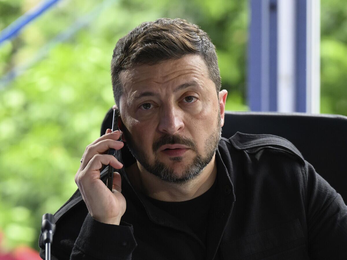    Владимир Зеленский разговаривает по телефону во время встречи на саммите Европейского политического сообщества в Тиране, Албания© AP Photo / Leon Neal