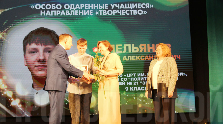 Заместитель управляющего администрацией Западного управленческого округа Александр Ковалёв и депутат полевской Думы Елена Соснина награждают лауреата премии в номинации «Творчество» Николая Емельянова, воспитанника Центра развития творчества имени Н.Е. Бобровой, его маму Ларису Михайловну благодарят за воспитание достойного сына