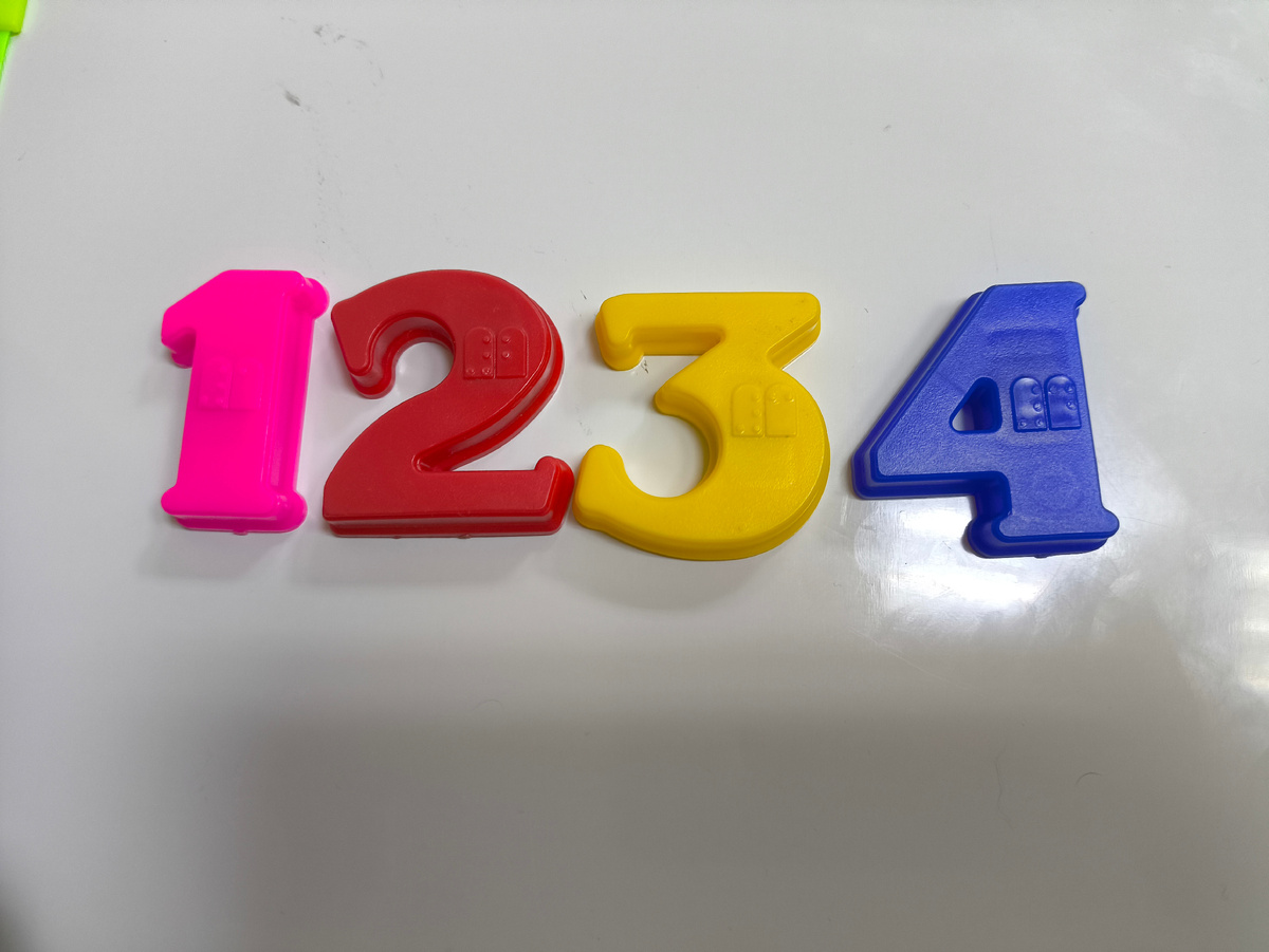 Цифры на пластиковой доске. На цифрах брайль 