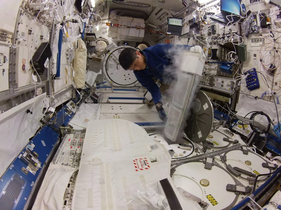 Такуя Ониси укладывает образцы в морозильник MELFI. Фото: nasa.blog.com