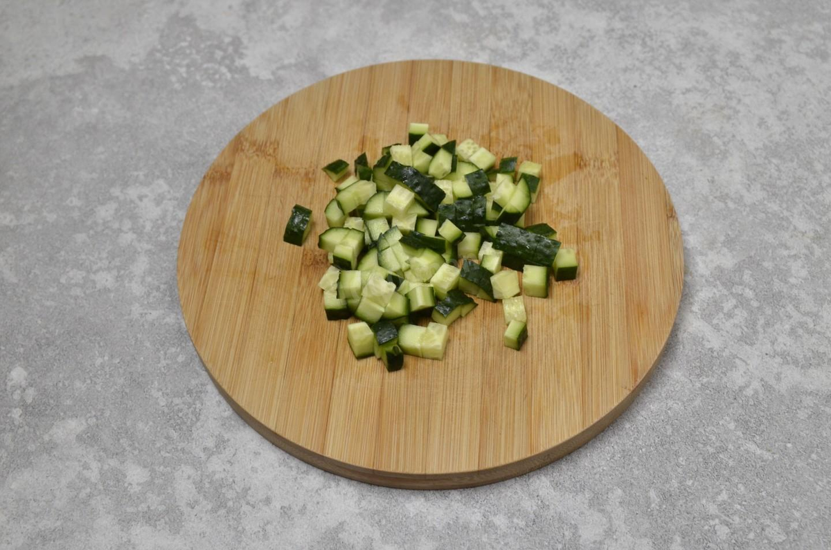 У огурца отрежьте кончики. Обязательно попробуйте, не горчит ли он — такой плод испортит вкус всего блюда. Нарежьте огурец небольшими кубиками.