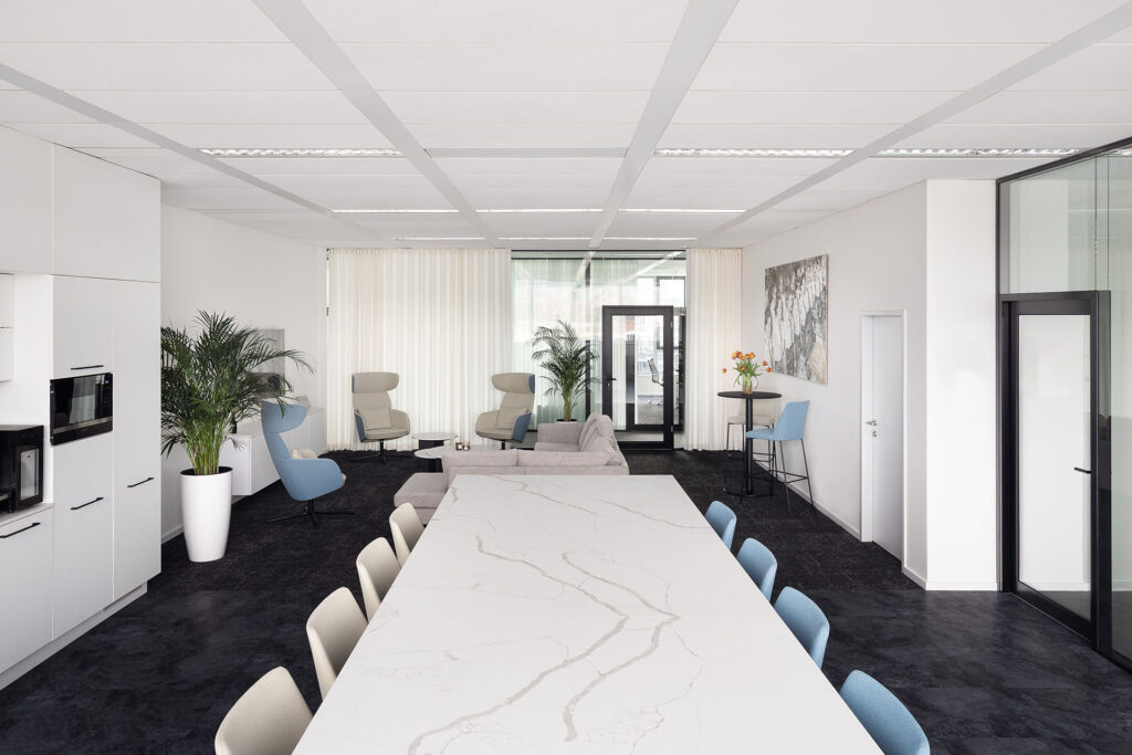 Столешница стола в декоре Crystal Calacatta Silva от TechniStone в конференц-зале Šenkýř Architekti; фотография Томаша Гавела