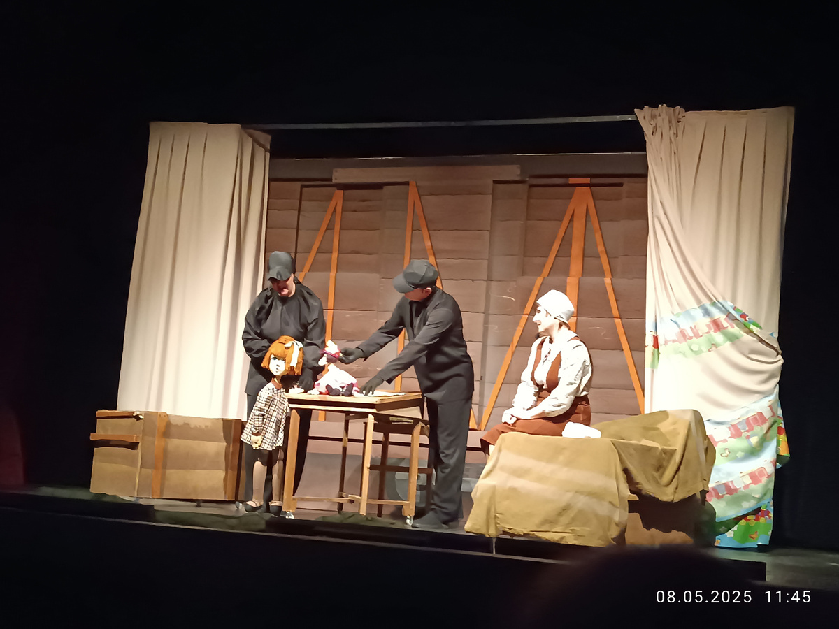 Тут бабушка – маленькая девочка (кукла, одивпбшая благодаря людям в чёрном). Рядом актриса в роли мамы маленькой бабушки.