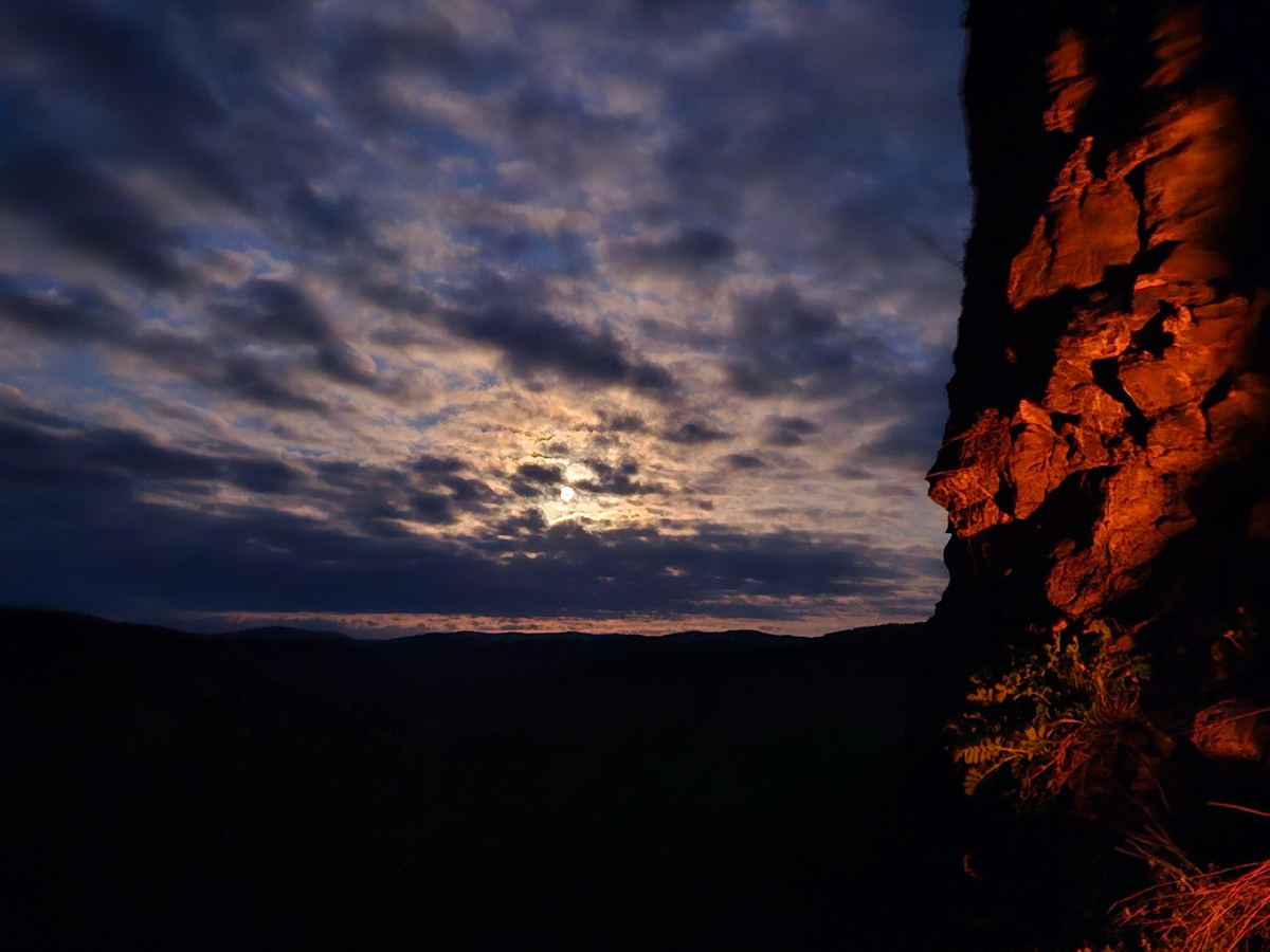 Луна пробивается сквозь облака и отблески костра на стене грота.