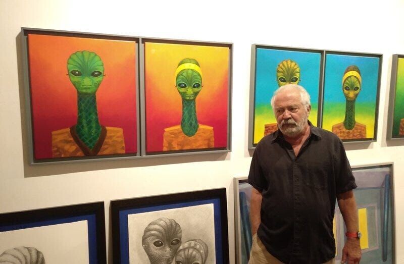 Художник Роберт Ллимос рядом со своими изображениями рептилий, которых он видел в Бразилии около 2009 года.