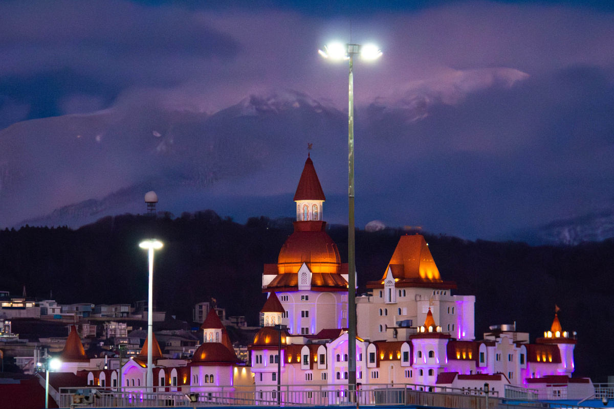 Развлекательный центр «Сочи Парк» на фоне покрытых снегом гор. Зимой он толком не работает, но выглядит все равно эффектно.