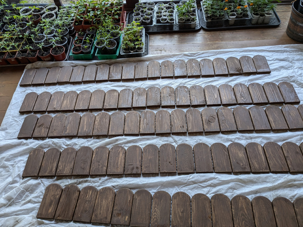 Деревянный заборчик для цветочно-овощного бордюра сохнет после пропитки