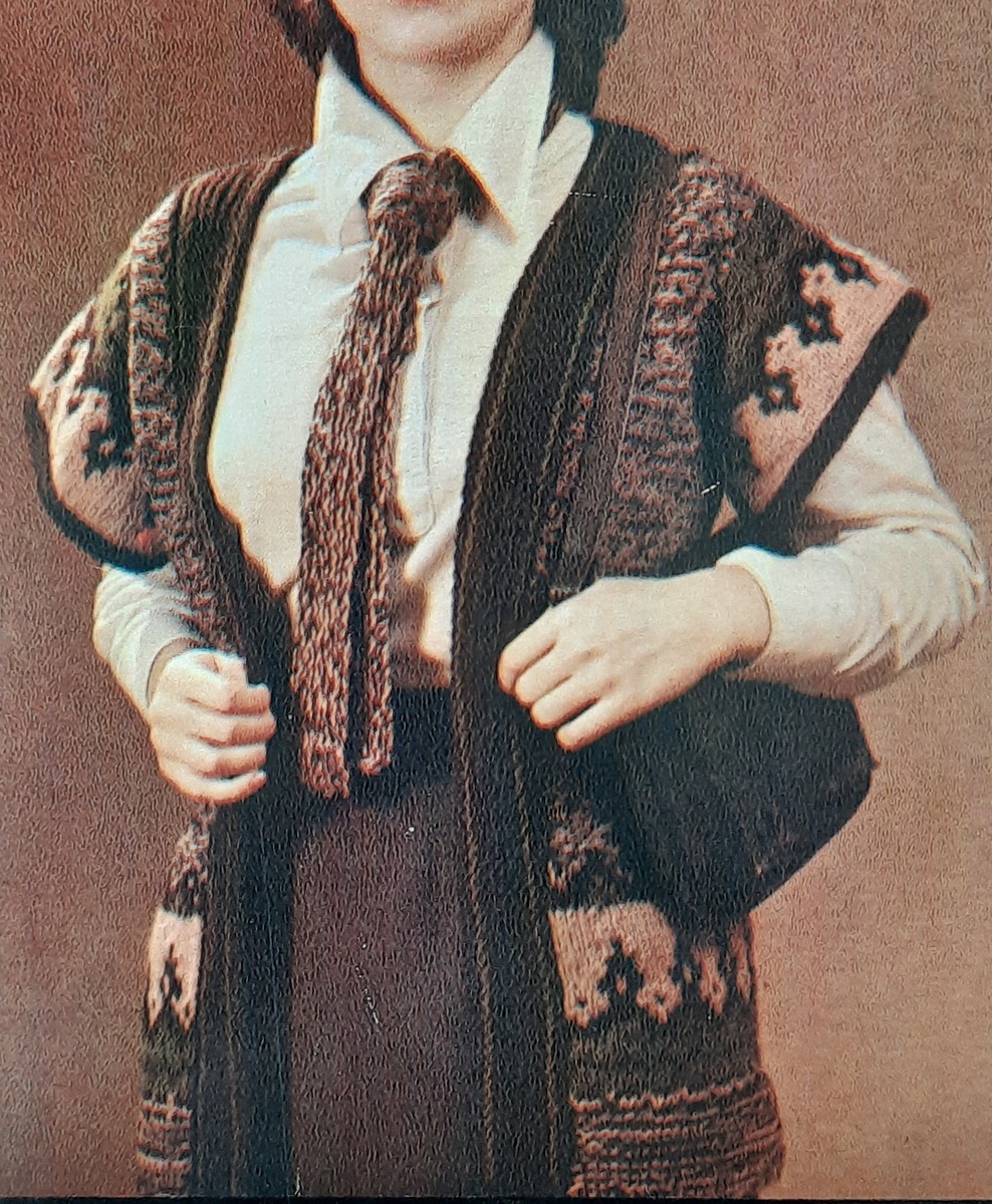 Начинать работу с низа полочки 5-6 см платочной вязки. Ширина полочки без отделочной вертикальной планки 22см(планку выполнить после того, как свяжите жилет). После платочного вязанья связать орнамент по схеме и далее вязать полочку до линии АБ. Вязанье оставить на спице. Затем точно также связать вторую полочку и, не обрывая нити, наберите воздушные петли для горловины спинки. Теперь провяжите этой же нитью петли др.полочки и на этом кол-ве петель свяжите спинку по выкройке.Нитью болотного цвета наберите петли для рукавов из вертикальных линий пройм (44см) и свяжите рукава, начиная с орнамента. Узор орнамента используйте без его верхней части. Закончите рукава 6р.платочной вязки из корич.нити. Пришейте рукава к горизонтальным участкам пройм(рукава не сшивайте). Сшейте боковые швы. Коричневой нитью наберите петли из кромочных полочек(по 1 п.из каждой кромочной) и свяжите отделочную планку со швом на спинке. Ширина планки 6-7см: 2р.корич.,2р.болтного цв.,10р.корич.,2р.болотного цв.,1р.корич.цв.,после этогопетли закрыть.