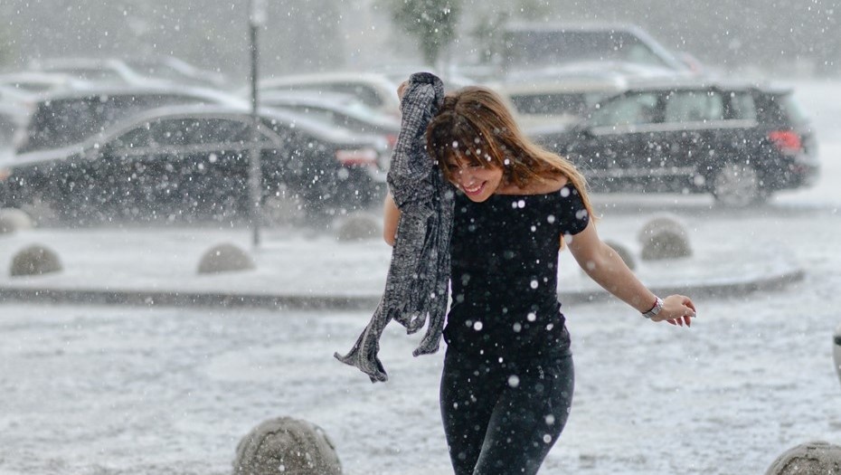    Жительница Петербурга бежит под навес, пытаясь не промокнуть во время дождя с градом. Автор фото: Сергей Ермохин / "Деловой Петербург"