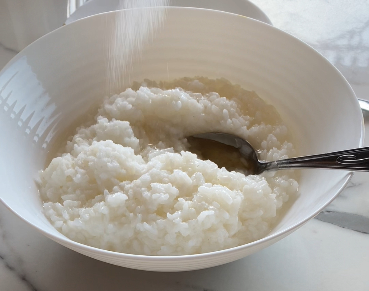 Добавить в отварной рис рисовый уксус, соль, мед. Перемешать.