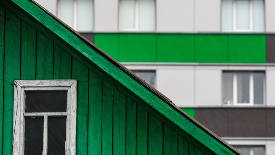    Частный дом деревянный дом на фоне новостройки в Октябрьском районе Новосибирска. Автор фото: Кирилл Кухмарь / ТАСС