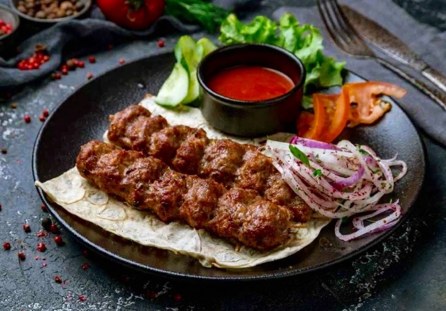 Люля-кебаб с луком и соусом.